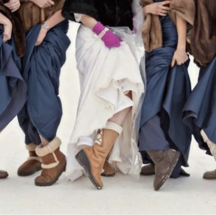 The bride and bridesmaids lifting their dresses to show their boots.