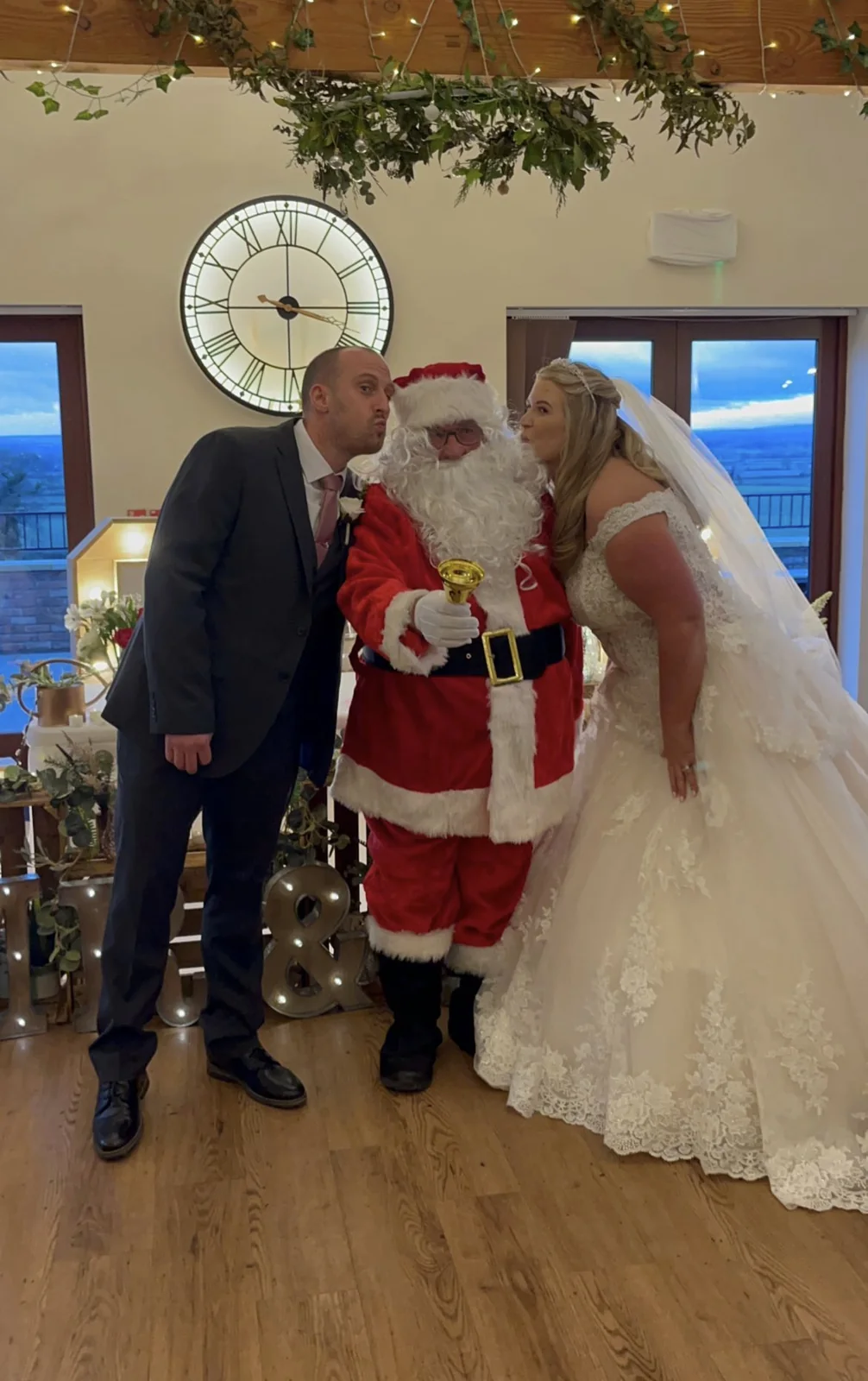 The newlyweds posing with a guest dressed as Father Christmas.