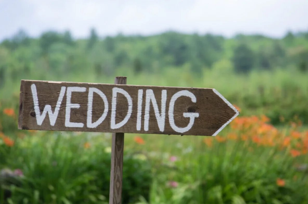 A wooden sign reading Wedding points across the countryside.