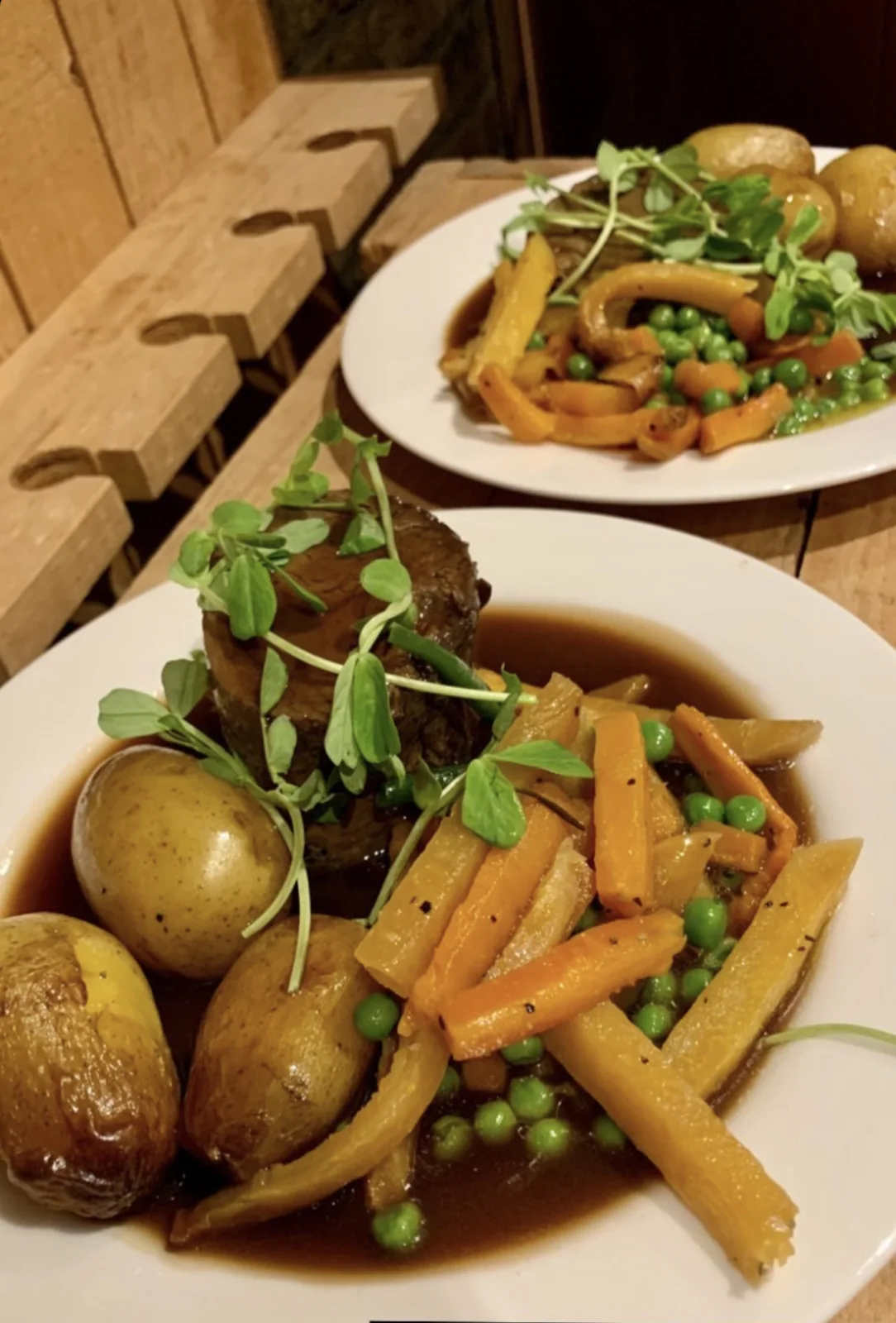 Plates of roast dinner with vegetables, potatoes and Yorkshire puddings.