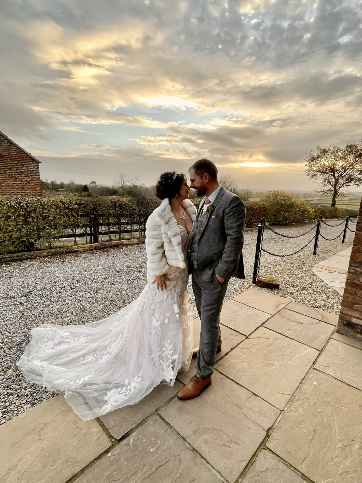The newlyweds embracing on the patio beneath a winter evening sky.