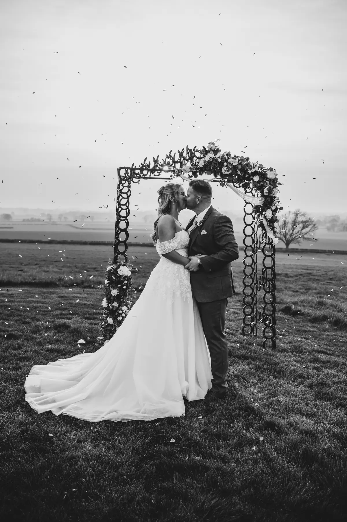 The couple kissing beneath the horseshoe arch in black and white
