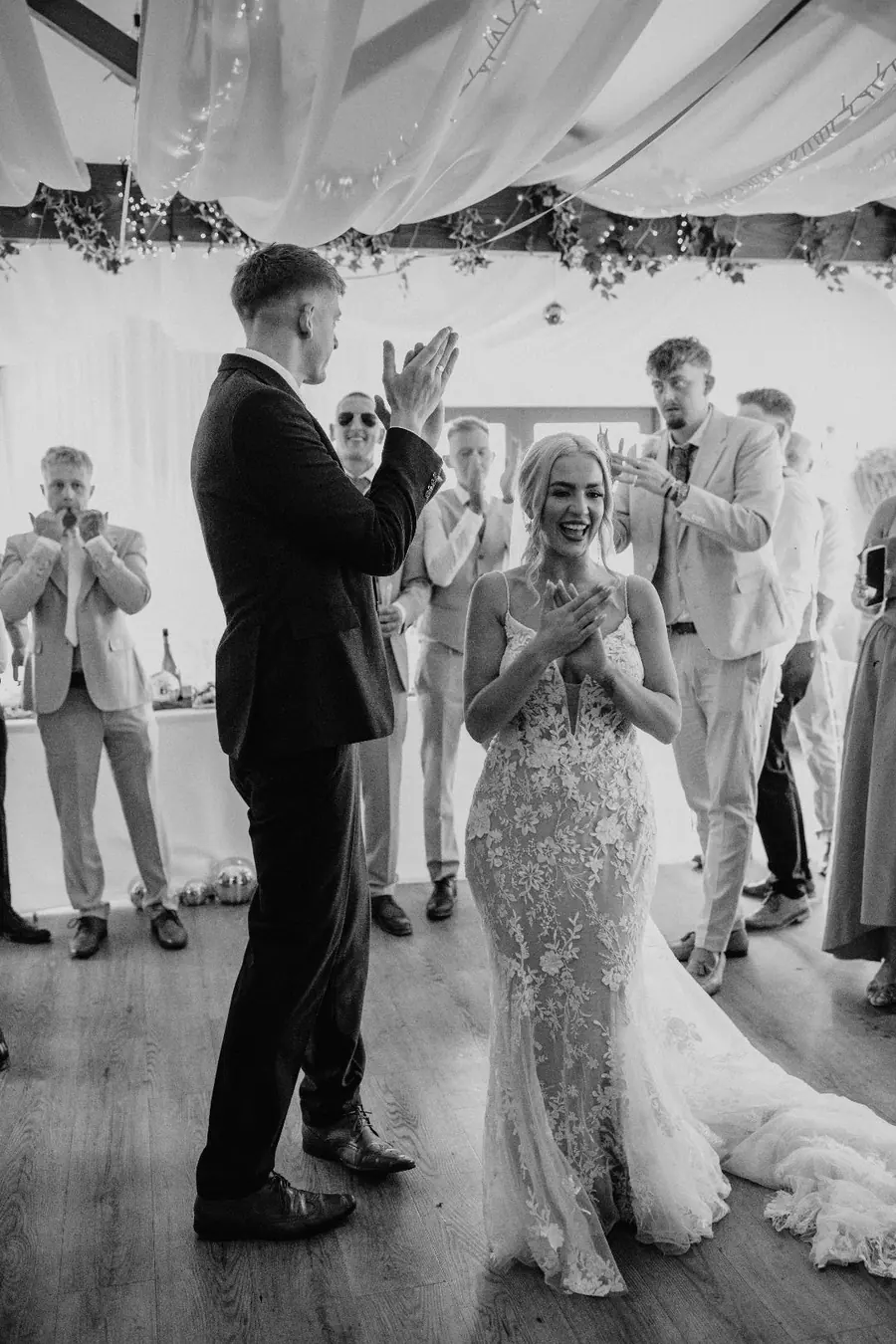 Guests applauding as Harriet walks through the Hall beside Jack