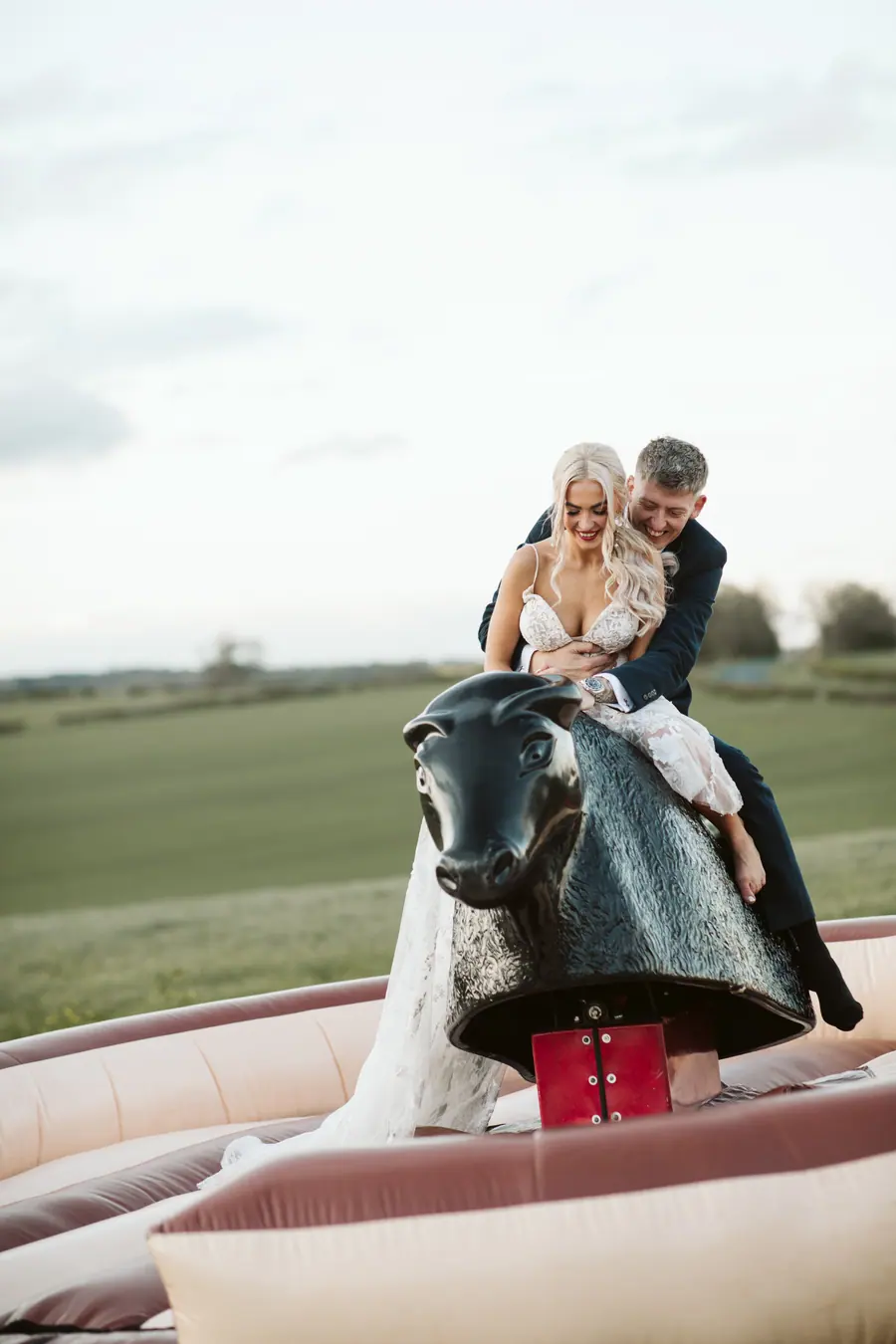 Jack and Harriet riding the inflatable rodeo game together outdoors