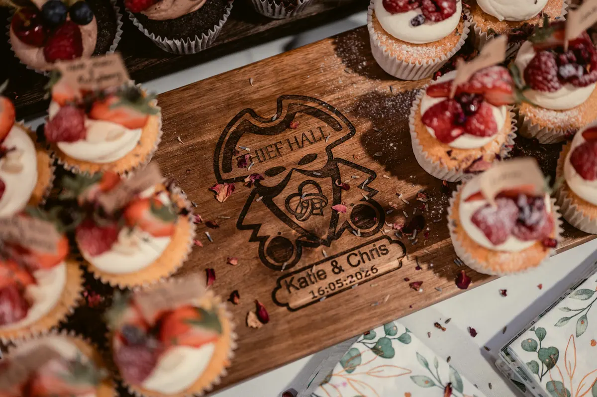 Fruit-topped cakes displayed around a wooden board bearing the couple's names