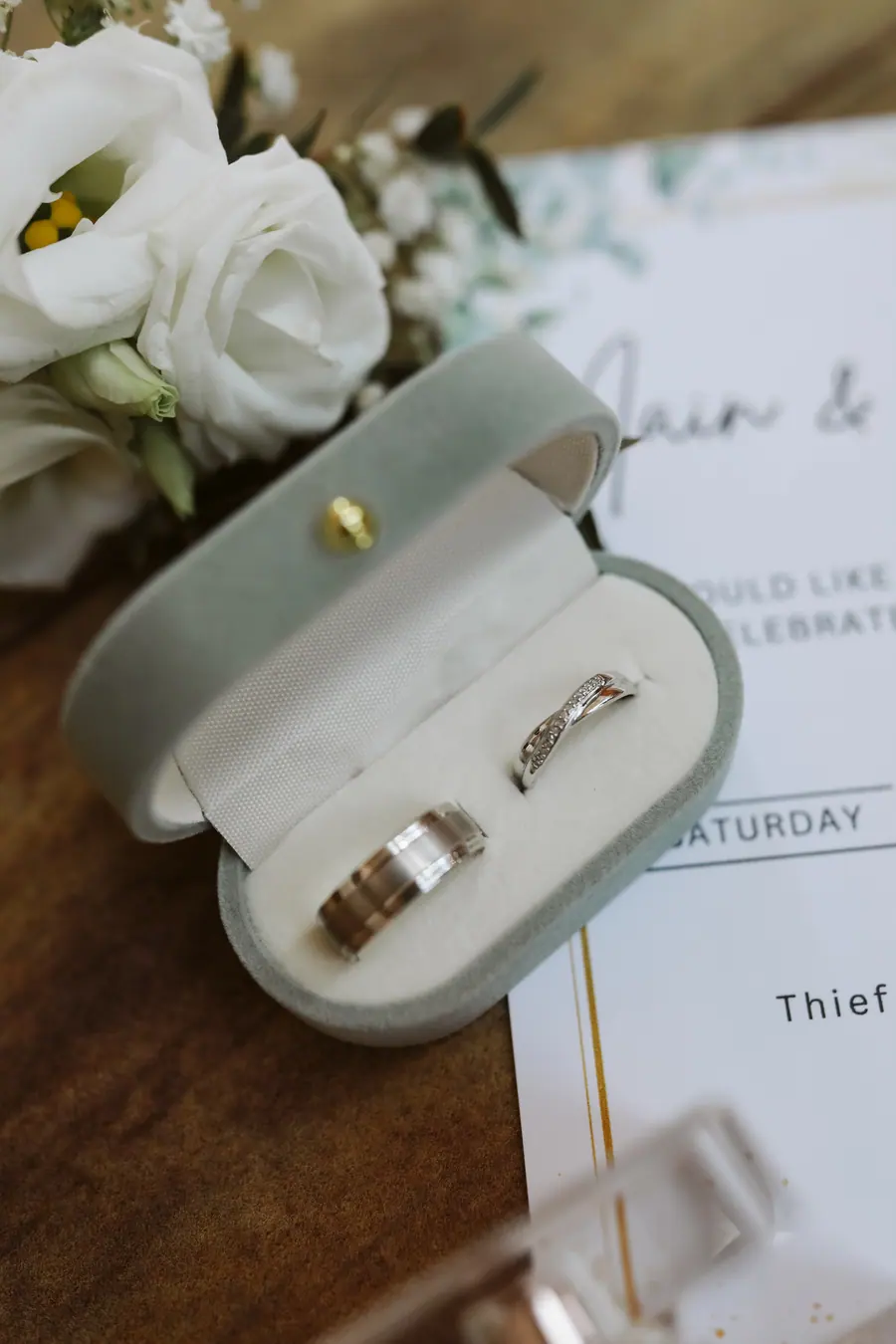 Two wedding rings displayed inside a pale green ring box