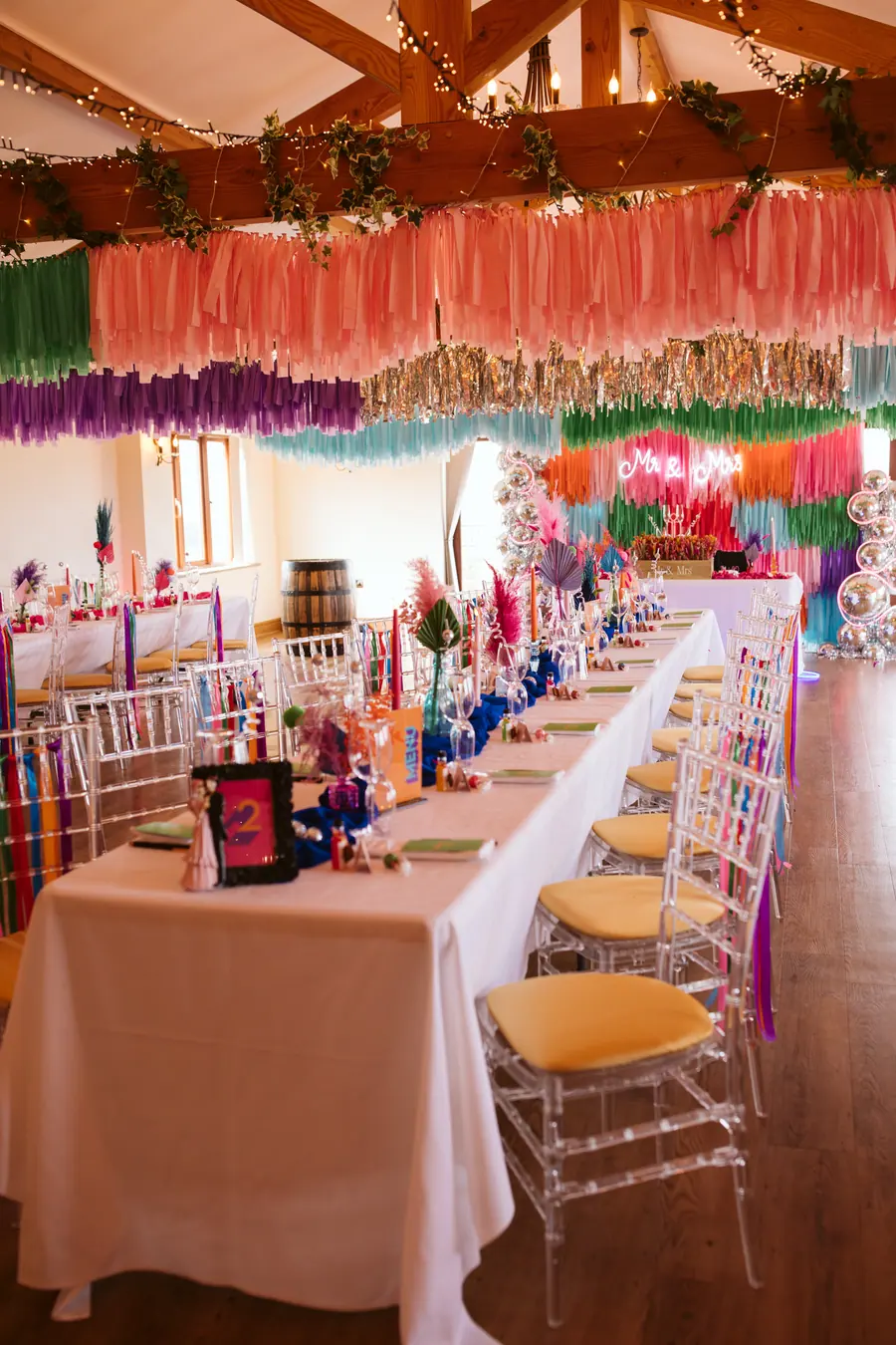 Hall tables dressed with coloured glass and layered ceiling fringe