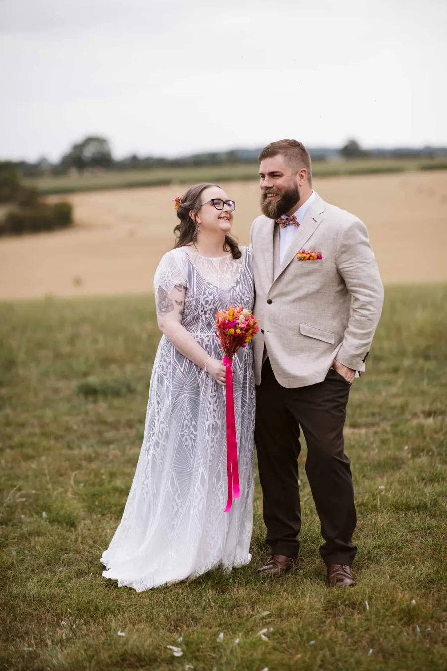 Lauren and Martin standing together in the field beneath an open sky