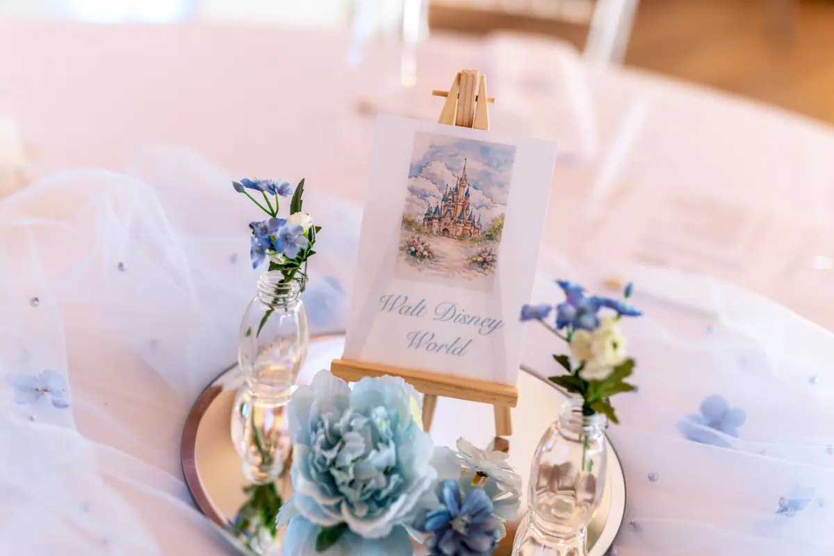 Small blue flowers and pale place card arranged on a laid table