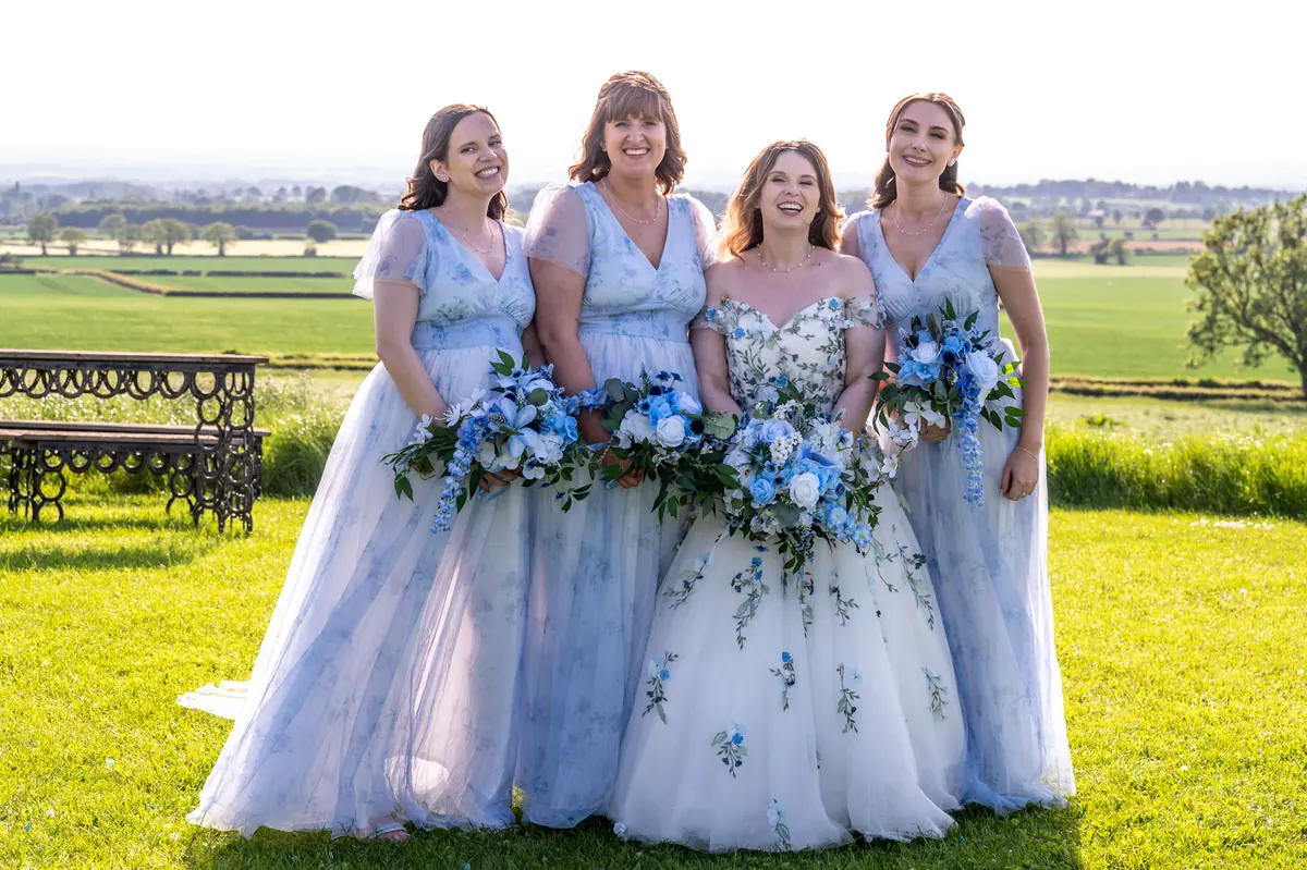 Megan with three women in pale blue floral dresses outdoors
