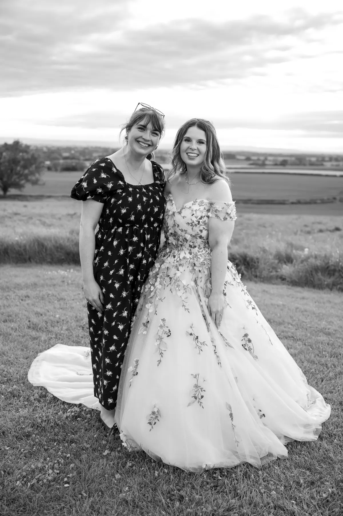 Megan standing beside another woman against the fields in monochrome
