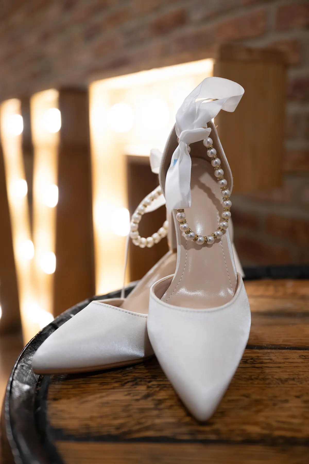 Single white shoe resting against warm brickwork beside the Hall