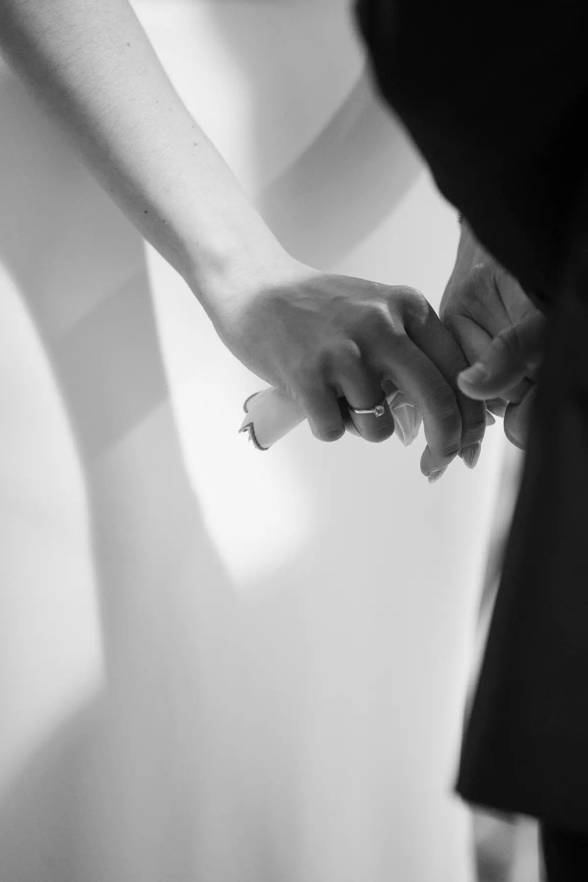 Close black and white view of Natalie and Alex holding hands
