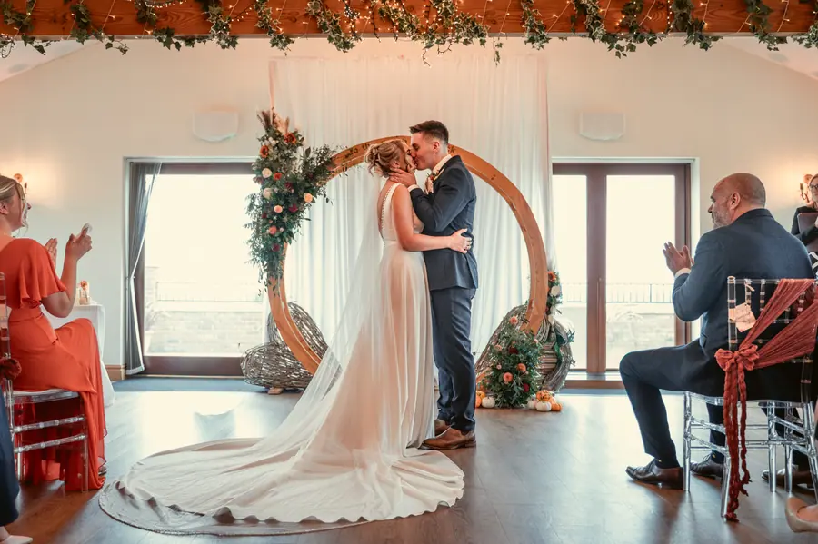 Olivia and Granville standing beneath the circular arch during their ceremony