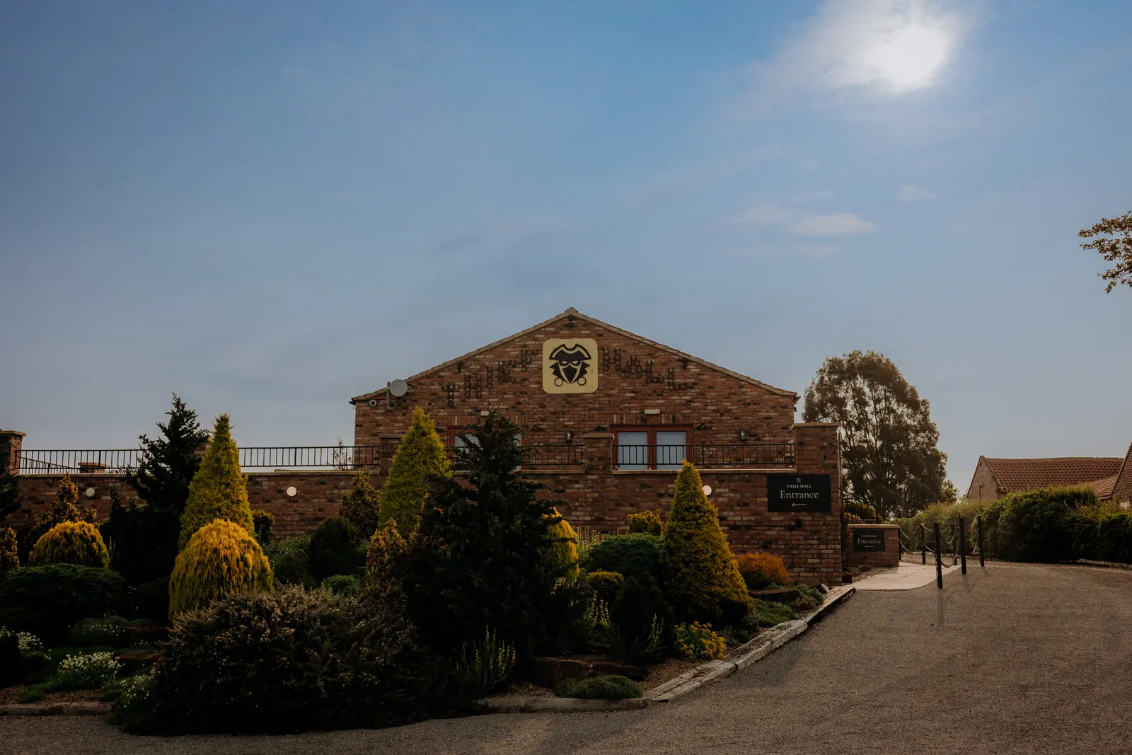 Brick Thief Hall entrance and courtyard beneath a deep blue sky