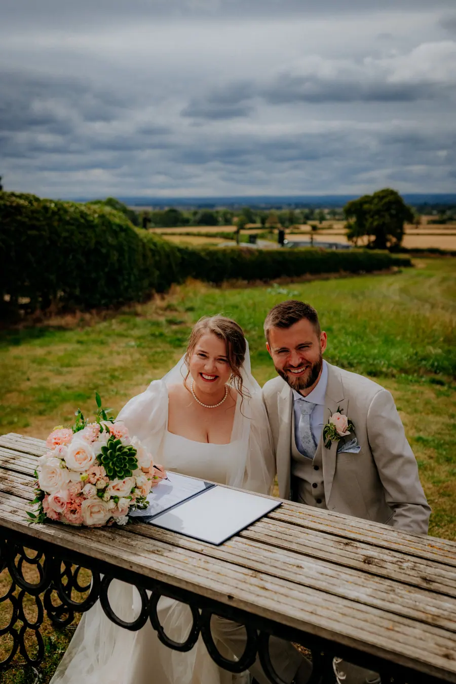Rae and Ben signing the register beside the ceremony benches