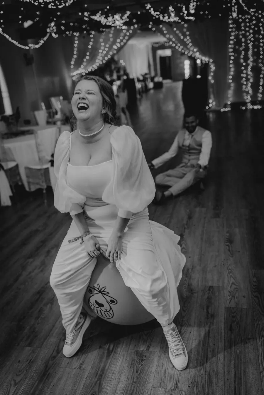 Rae raised on a guest's shoulders while laughing on the dance floor