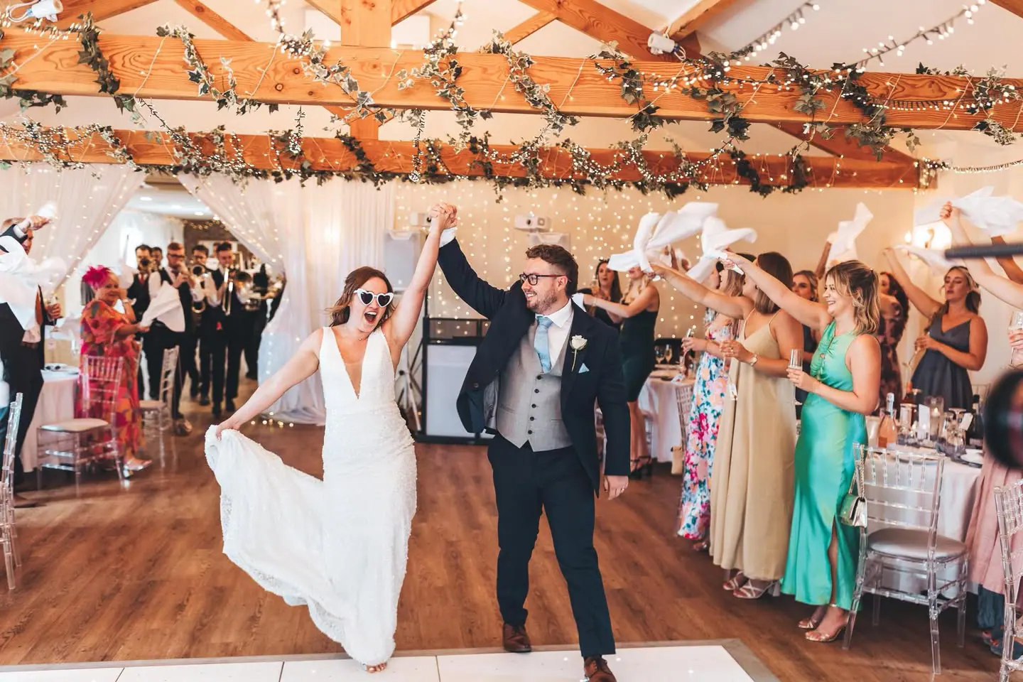 Sophie and Jake entering the Hall beneath raised white napkins