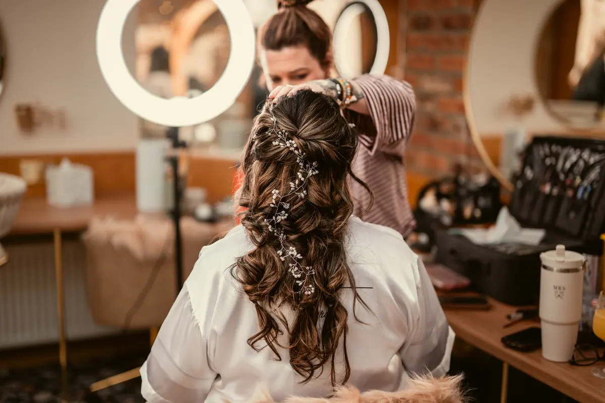 Stylist arranging Star's curled hair beside the round preparation mirrors