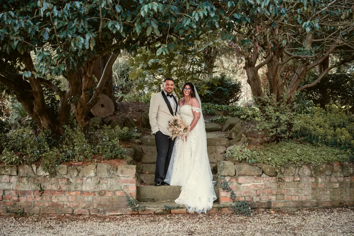Star and Dan standing together on stone steps among woodland plants