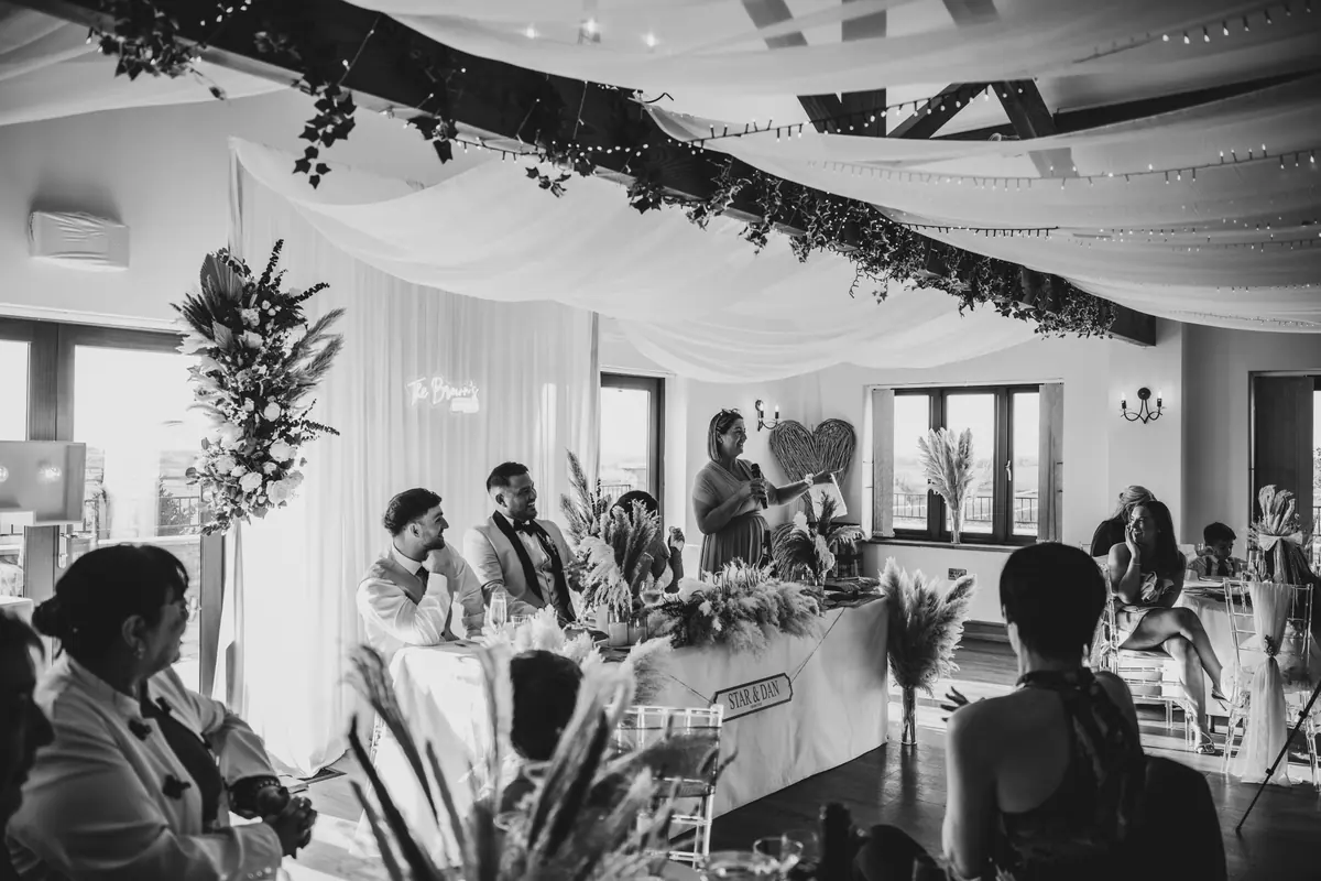 Guests listening to speeches around laid tables inside the Hall