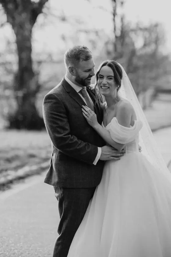 Zoe and Scott standing together outdoors in a black and white close view