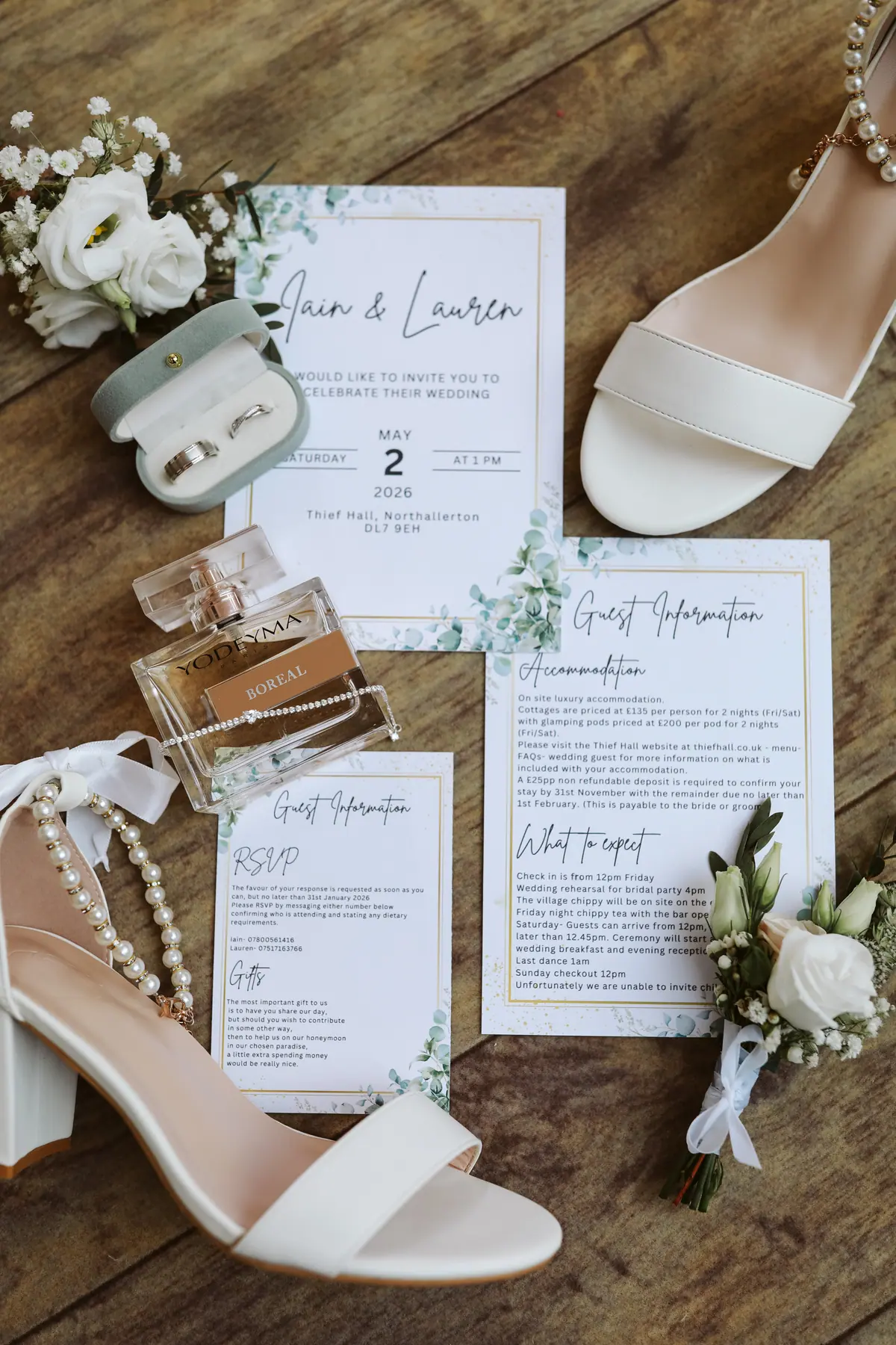 Wedding stationery, jewellery and bridal shoes arranged on a wooden table