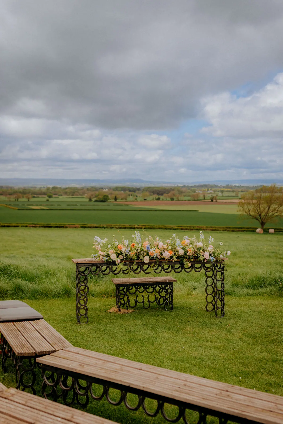 A wooden bench looking across the open fields at Thief Hall