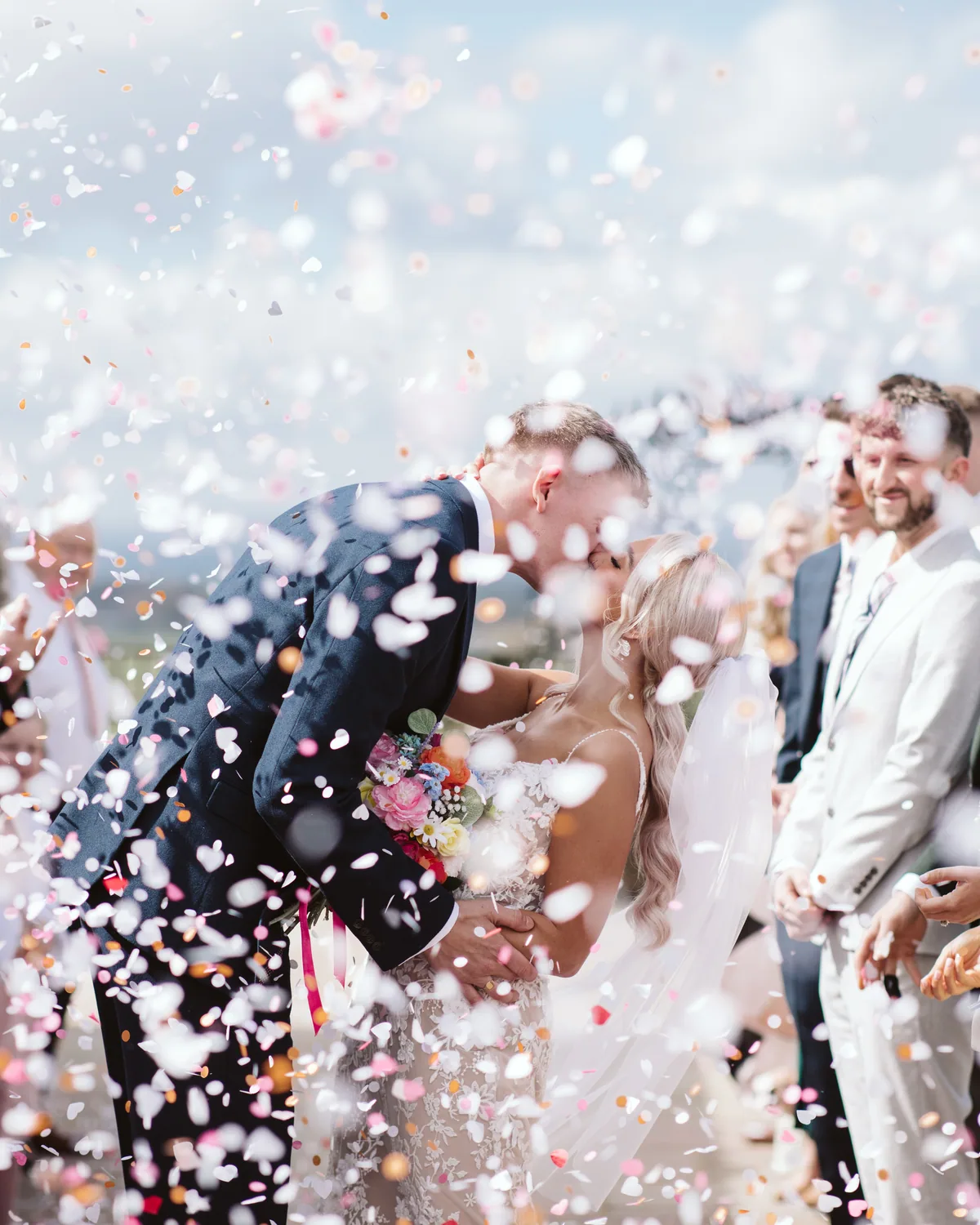 Guests throwing confetti over newlyweds at Thief Hall