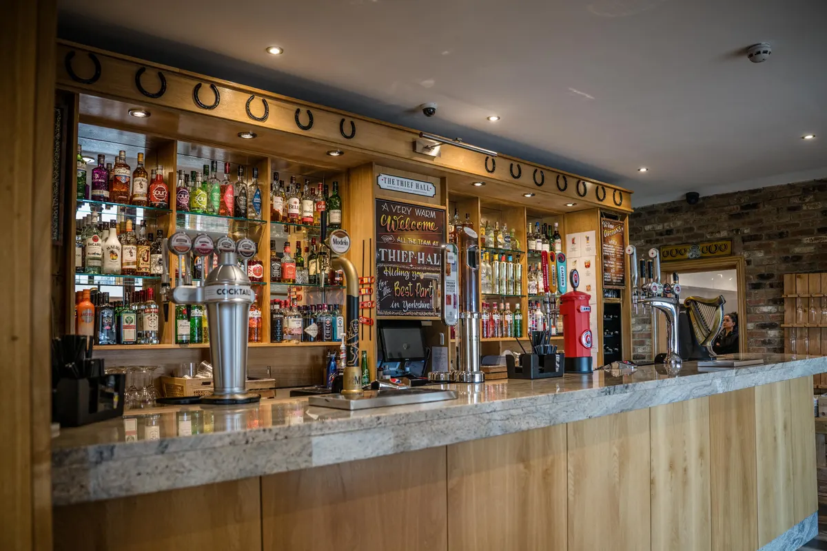 The stocked Thief Hall bar beneath its row of horseshoes