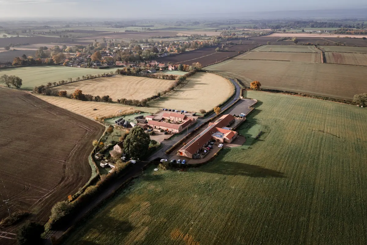 Aerial view of Thief Hall’s converted farm buildings, cottages and pods surrounded by North Yorkshire fields