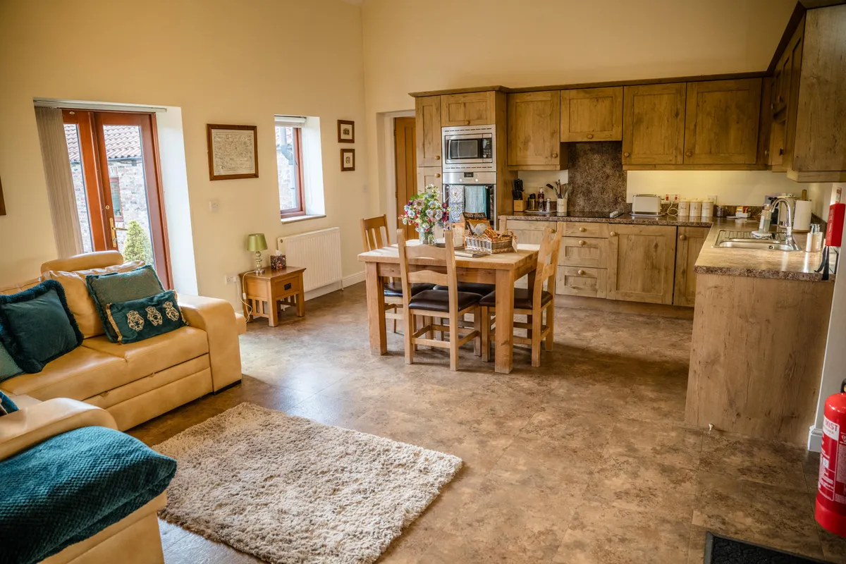 The kitchen, dining table and sofa in Fawkes Cottage